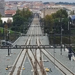 Train tracks merging in the distance with the city